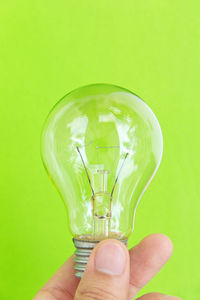 Close-up of hand holding light bulb