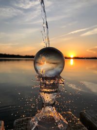 Close-up of crystal ball against sky during sunset