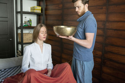 Beautiful woman meditating with singing bowl