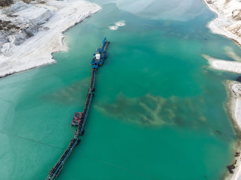 Aerial view of the long boom of a suction excavator in a quartz quarry for the excavation