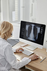 Doctor examining x-ray image on desktop pc in clinic