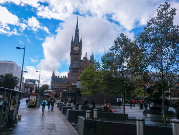 Tourists at church against cloudy sky