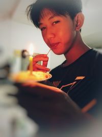 Portrait of boy holding lit candle