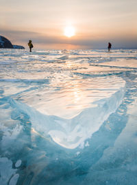 Distant view of people on glacier during sunset