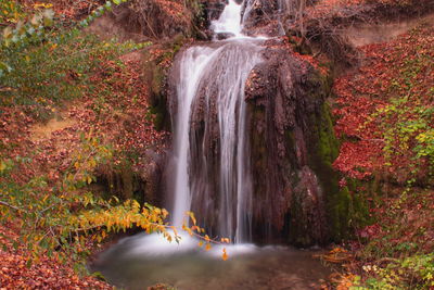 Scenic view of waterfall in forest during autumn