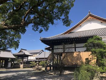 View of temple by building against sky