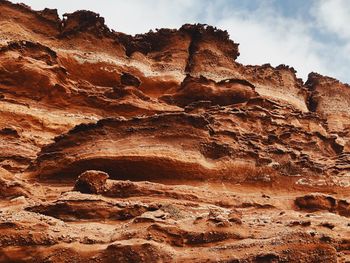 Low angle view of rock formation on land against sky