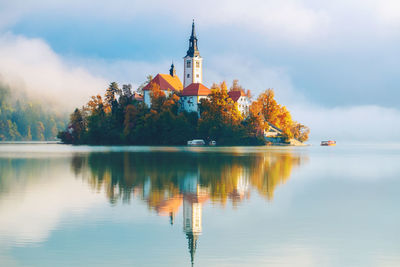 Scenic view of lake by building against sky