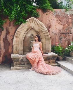 Woman standing against stone wall