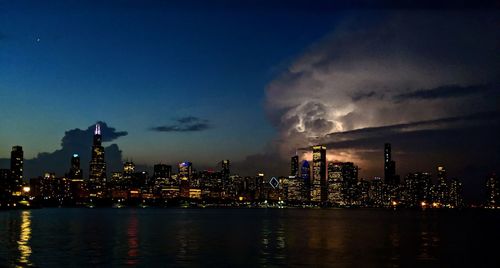 Illuminated city by approaching storm on the lake