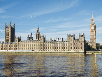 Panoramic view of buildings by river against sky in city