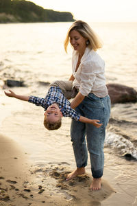 Mother and son having fun and playing at the seaside. summer vacation.
