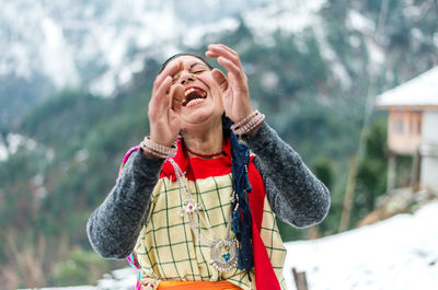 Portrait of smiling woman standing in snow