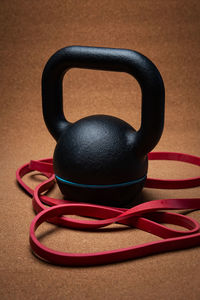 Close-up of kettlebell with rubber bands against brown background