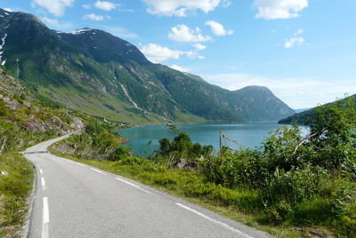 Road by mountains against sky