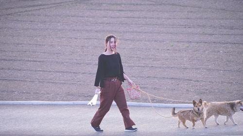 Full length of woman with dog standing on shore