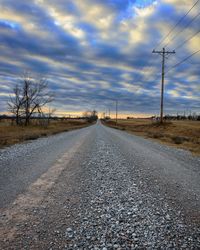 Road by trees against sky