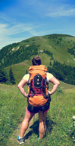 Rear view of a woman walking on mountain against sky