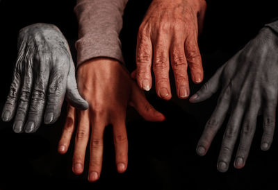 Close-up of cropped hands against black background