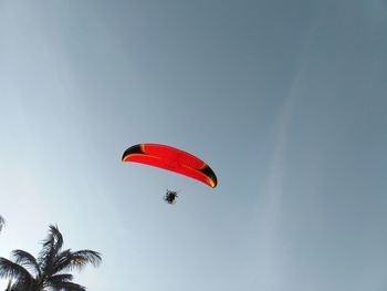 Low angle view of person paragliding against sky