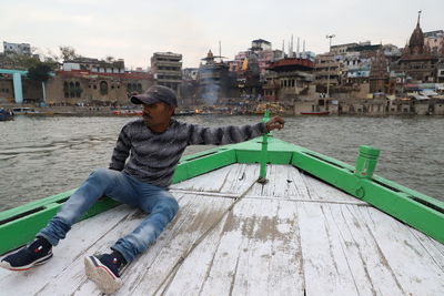 Man sitting on boat in city