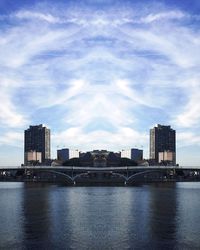 City at waterfront against cloudy sky