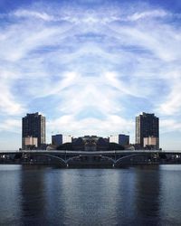 City at waterfront against cloudy sky