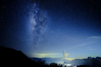 Low angle view of silhouette mountain against star field