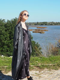 Young woman wearing sunglasses while standing on land