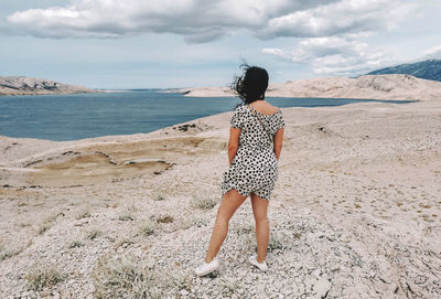 Rear view of woman standing on beach