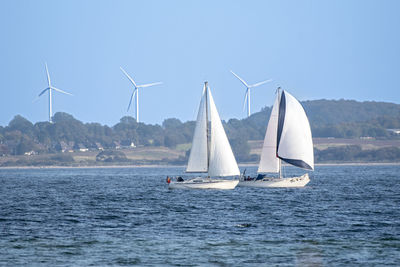 Sailboat sailing on sea against sky