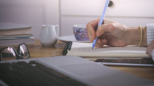 Midsection of man reading book on table