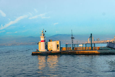 Lighthouse by sea against sky