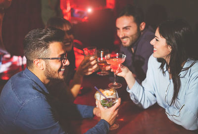 Happy friends having cocktail in restaurant at night