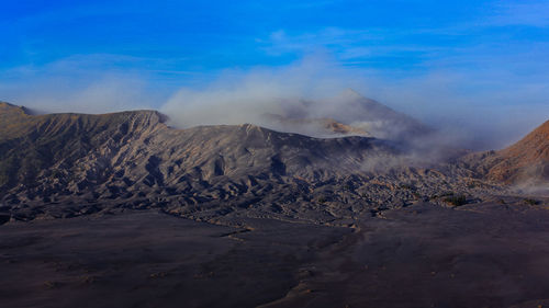 Smoke emitting from volcanic mountain against sky