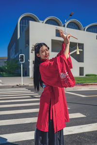 Portrait of young woman standing against wall