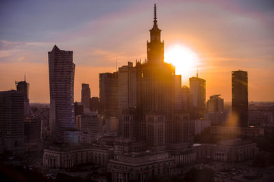 Skyscrapers in city at sunset