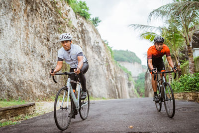 Full length of man riding bicycle on road