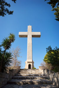 Low angle view of cross against clear blue sky