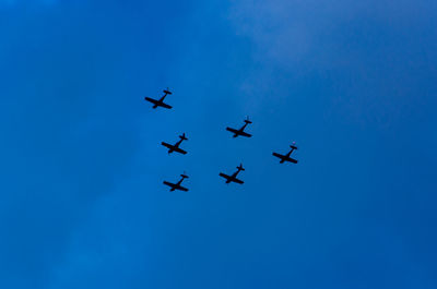 Low angle view of airshow against clear blue sky