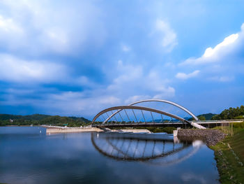 Arch bridge over river against sky