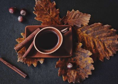 Directly above shot of coffee on autumn leaves at table