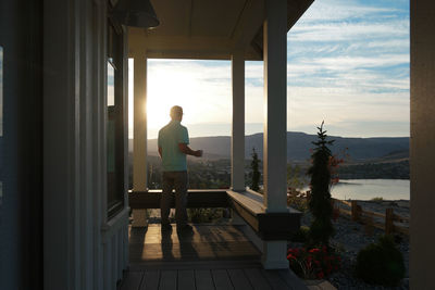 Man standing by window in sea