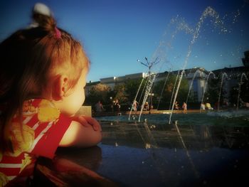 Portrait of girl with swimming pool against sky