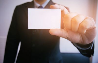 Cropped image of businessman holding business card