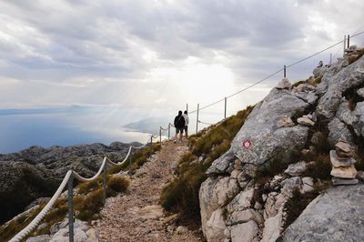 Man standing on mountain against sky