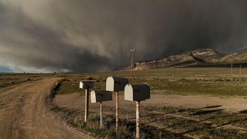 Mailboxes in row on dirt road at countryside landscape