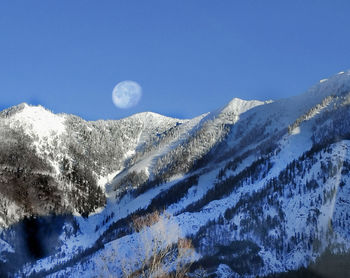 Scenic view of snowcapped mountains against clear blue sky