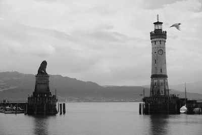 Lighthouse by sea against sky