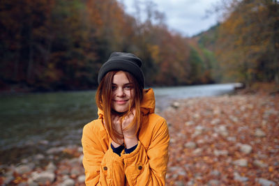 Portrait of young woman in park during autumn